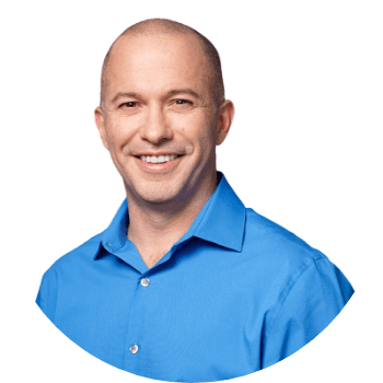 Headshot photo of a man in a bright blue dress shirt smiling