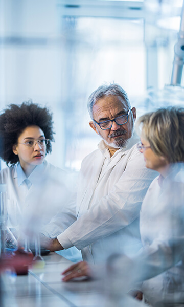 team members in white coats discussing and collaborating